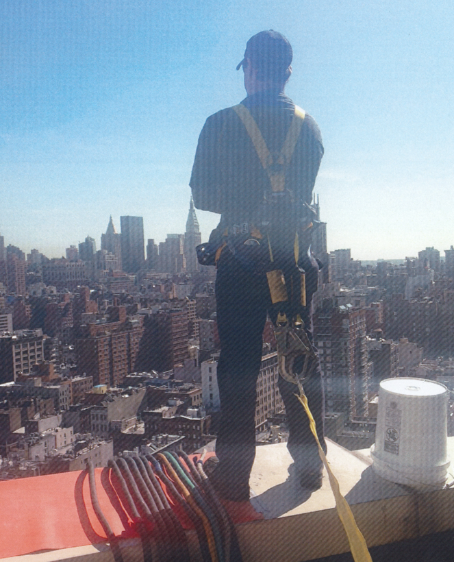 Generator technician standing on the roof of a building in Boston while performing a load bank test on a generator. 