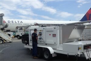 Generator technician using load bank trailer at Logan international airport.