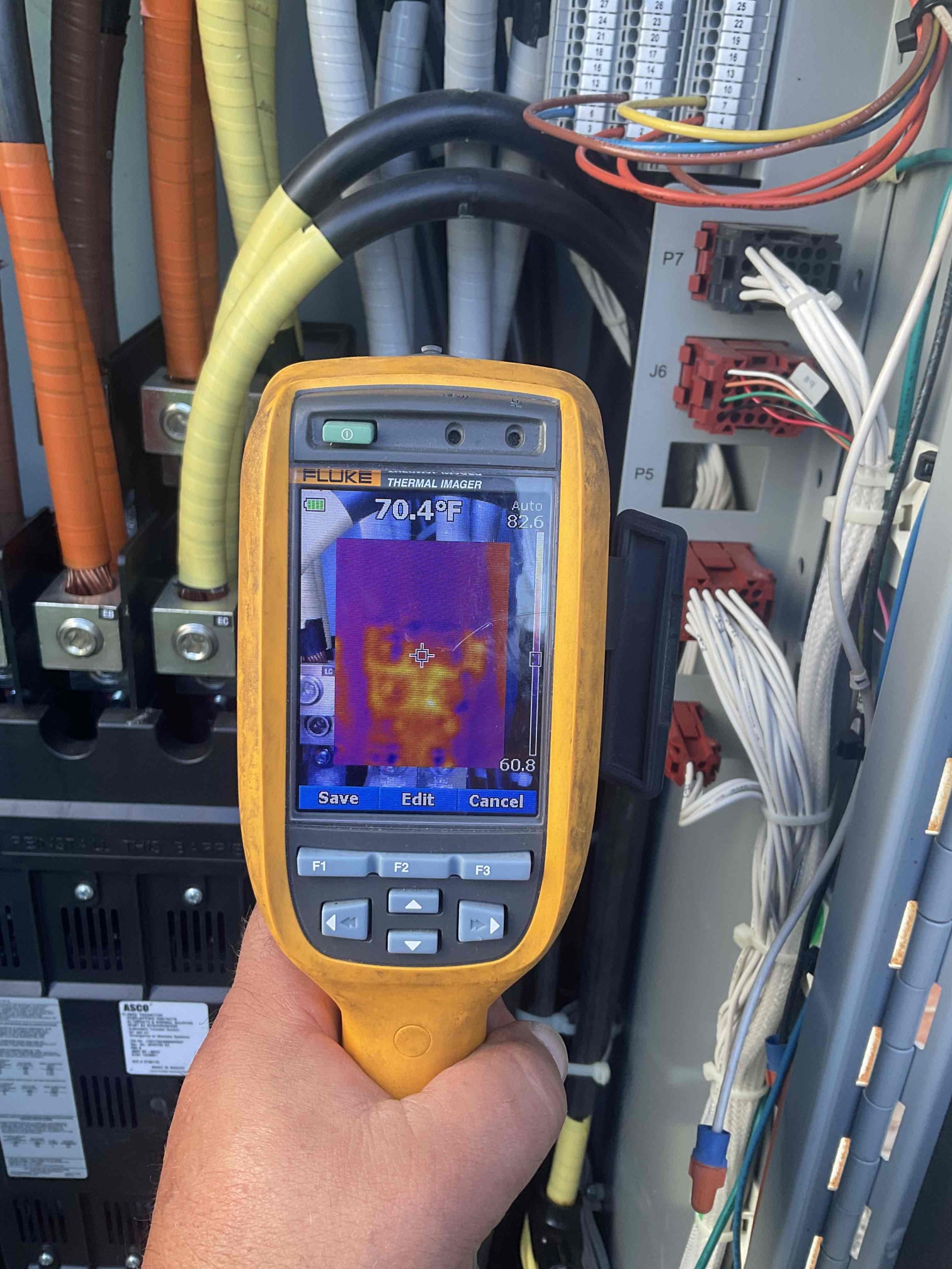 Weld Power Generator technician is holding a thermal imaging tool to check an ATS