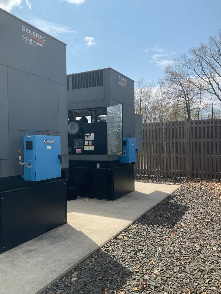 Two Generac generators powering a data center. The generators are sitting on a sub-base diesel fuel tank.