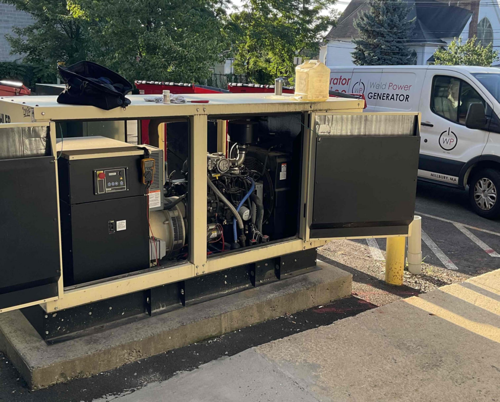 100 kW Kohler Commercial Standby Generator with a Weld Power Generator service vehicle in the background.
