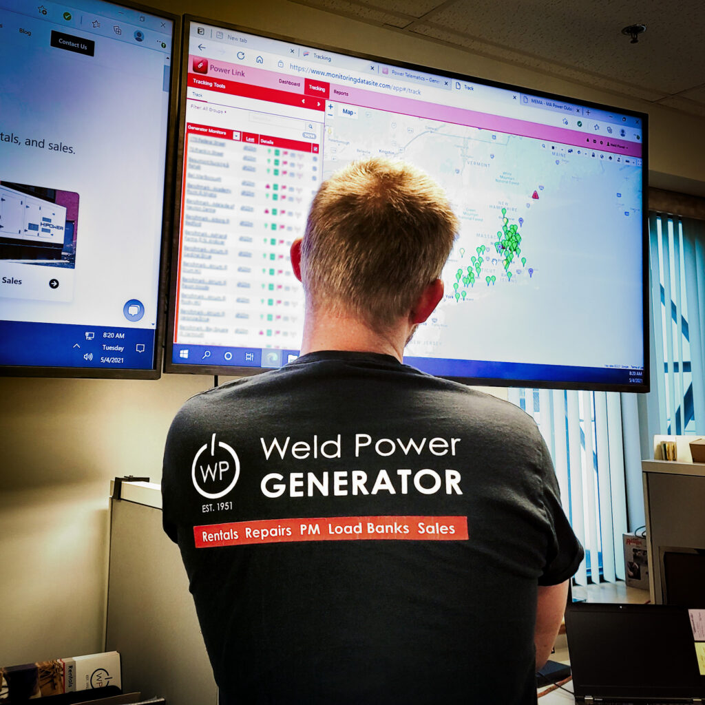 Weld Power generator technician looking at a TV displaying a map of generators with remote monitoring systems. The pins on the map change to indicate if there is a problem with a generator. 